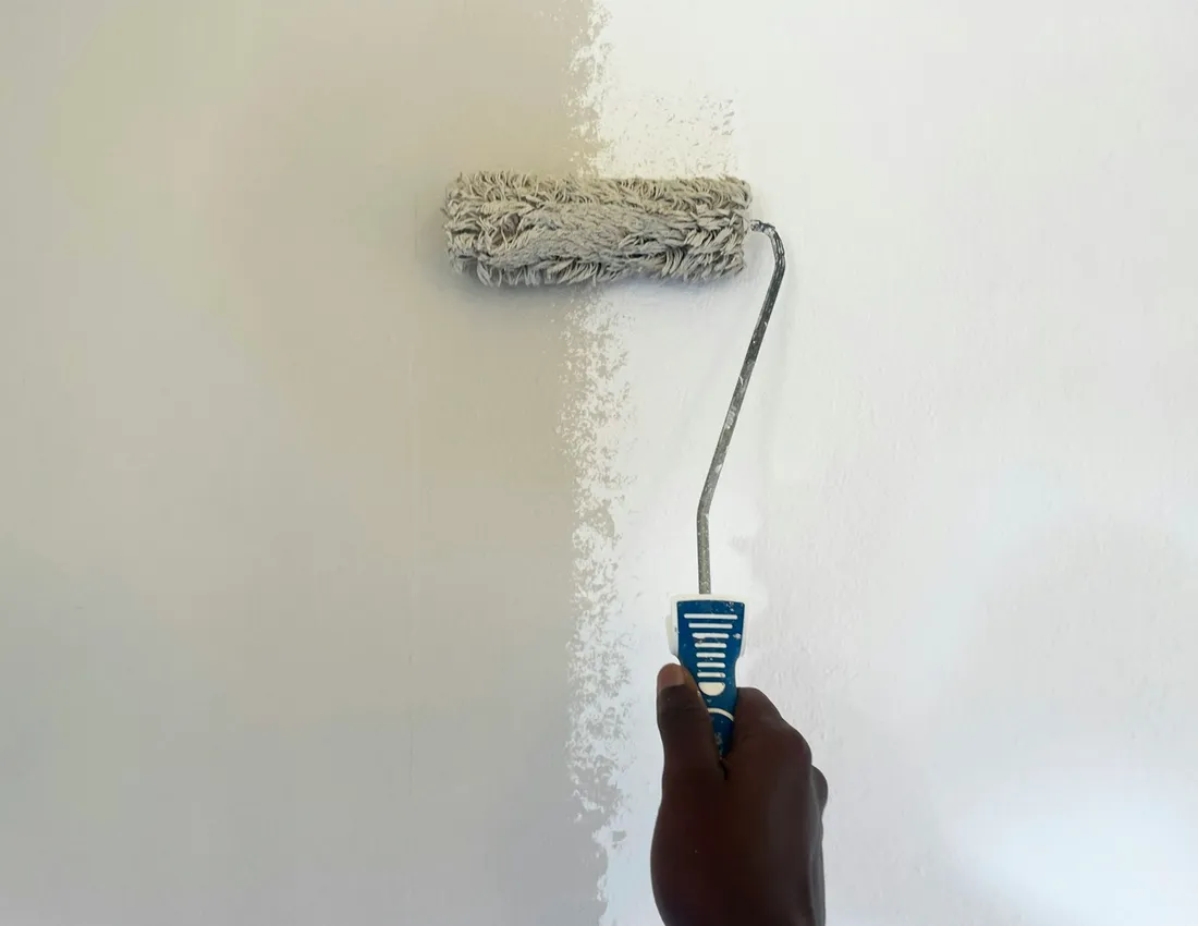 A roller applying light paint to an interior wall