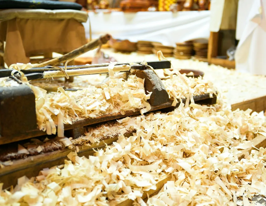 A hand plane and wood shavings on a timber workbench